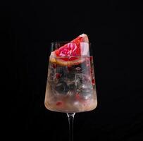 Elegant cocktail with citrus garnish on dark background photo