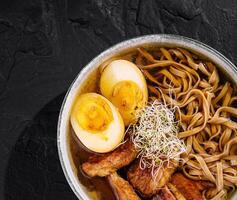 Savory ramen bowl with eggs and pork photo