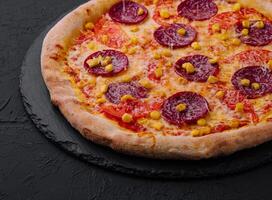 Appetizing pepperoni pizza on black background photo