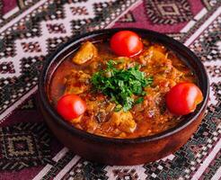 Traditional clay pot stew with fresh herbs photo