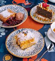 Assorted desserts with ice cream on a colorful tablecloth photo