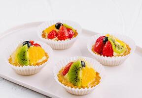 Fresh fruit tartlets on white plate photo