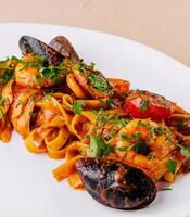 Delectable seafood pasta on white plate photo