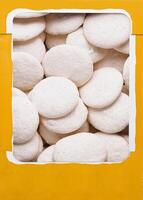 Box of white meringue cookies top view photo