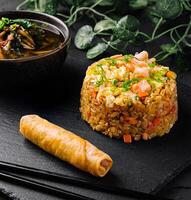 Asian cuisine delight fried rice, spring roll, and soup photo