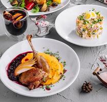 Vibrant holiday table setting featuring succulent roasted duck, salad, and mulled wine photo