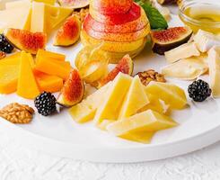 Gourmet cheese and fruit platter on white background photo