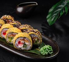 delicioso Sushi rollos chapado en oscuro pizarra antecedentes foto