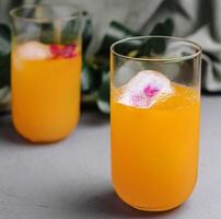 refrescante naranja cóctel con floral hielo cubitos foto