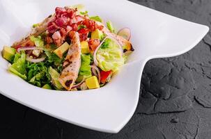 Fresh chicken and bacon salad on modern plate photo