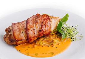 Juicy grilled pork loin on white plate with sauce photo