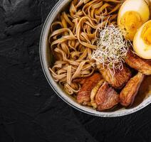 Savory ramen bowl with eggs and pork photo