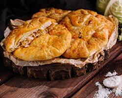 Rustic homemade cabbage pie on wooden table photo