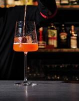 Bartender pouring a cocktail at a bar photo