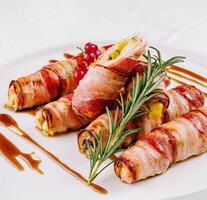 Bacon-wrapped stuffed jalapenos on plate photo