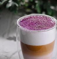 Colorful layered latte in a glass mug photo