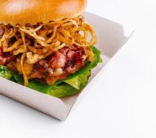 Gourmet burger with crispy onions in takeout box photo