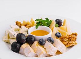 Gourmet cheese platter with honey and fruits photo