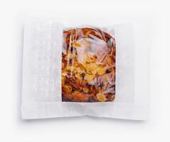 Almond croissant in paper bag isolated on white photo