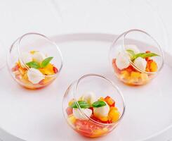 Elegant fruit salad in glass bowls photo