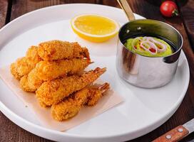 Fried shrimp platter with dipping sauce close up photo