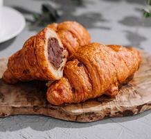 Chocolate-filled croissants on wooden board photo