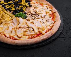 Half and half gourmet pizza on black background photo