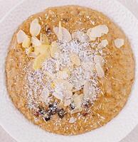 Almond and coconut porridge in white bowl photo