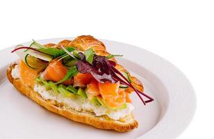 Gourmet smoked salmon croissant sandwich on white photo