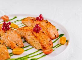 Grilled salmon fillets with berries and pesto sauce photo