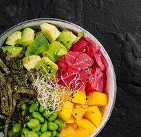 Colorful poke bowl on dark background photo