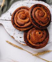 Rustic cinnamon rolls and blank card on wooden board photo