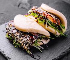 Asian fusion gourmet bao bun on slate background photo