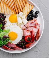 Full breakfast plate with eggs, bacon, and toast photo