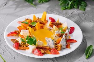 colorful salad with cheese and strawberries on elegant plate photo