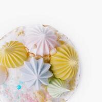 Colorful meringue topped cake on white background photo