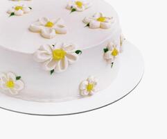 White fondant cake adorned with sugar daisies on a clean background photo