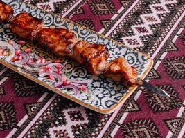 Traditional grilled meat skewers on ornate plate photo
