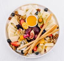 Gourmet cheese platter with fruits and nuts photo