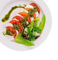 Fresh caprese salad with pesto drizzle photo