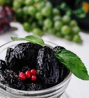 Gourmet fresh prunes in glass bowl with mint garnish photo