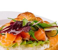 Gourmet smoked salmon croissant sandwich on white photo