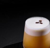 Classic whiskey sour cocktail with frothy top, served on a dark, moody background photo