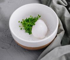 Poached egg with microgreens on ceramic plate photo