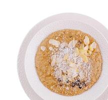 Almond and coconut porridge in white bowl photo