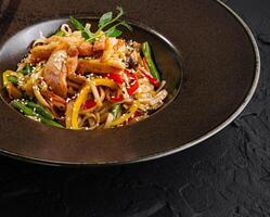 Asian-style stir fry noodles with vegetables and chicken photo