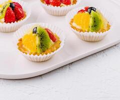 Fresh fruit tartlets on white plate photo