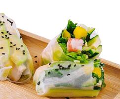 Fresh spring rolls on wooden plate photo