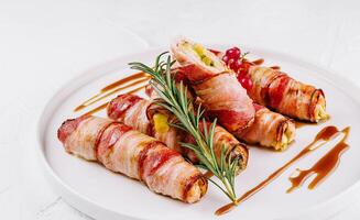 Bacon-wrapped stuffed jalapenos on plate photo