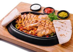 candente pollo fajitas plato con condimentos foto